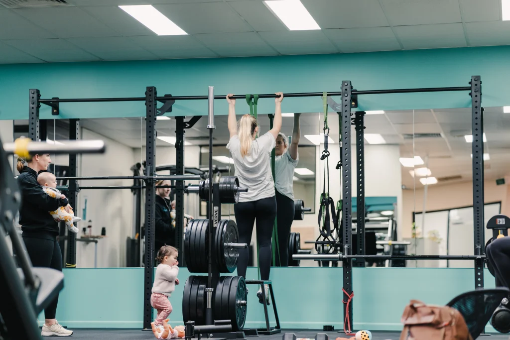 Mother completing strength and conditioning with their infants